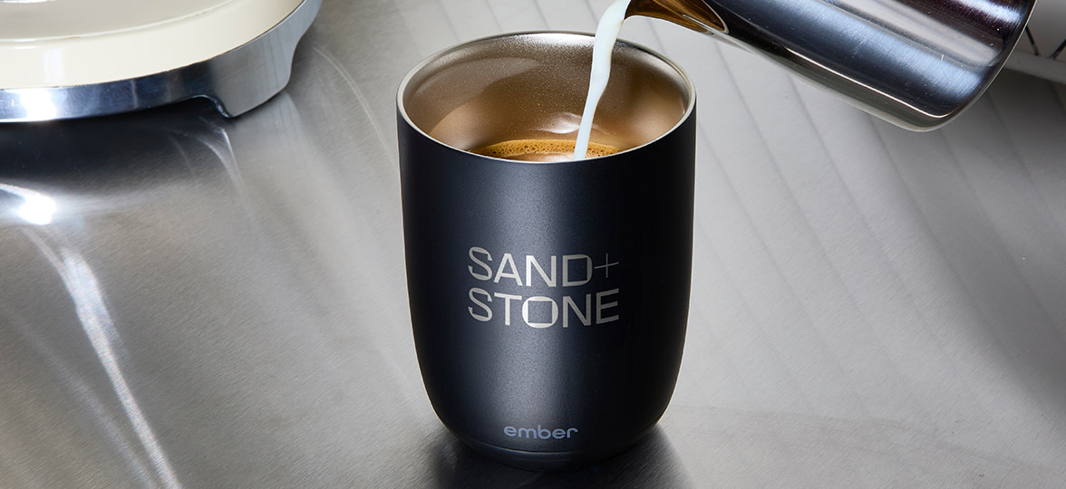 Someone pouring coffee into an Ember branded Mug.
