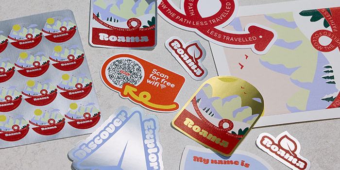 A range of branded, customized Die Cut Stickers on a flat grey surface.