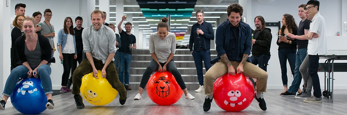 MOO employees using colorful space hoppers in the office showing a positive company culture and work life balance