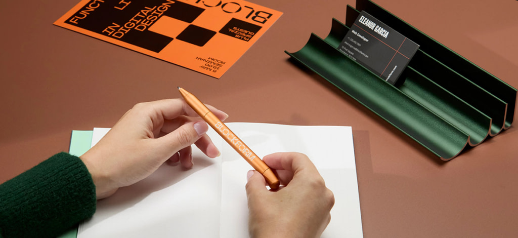 Person holding branded Twist Pen over Notebook.