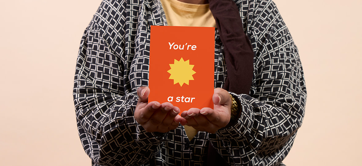 A woman holding a gifted postcard.