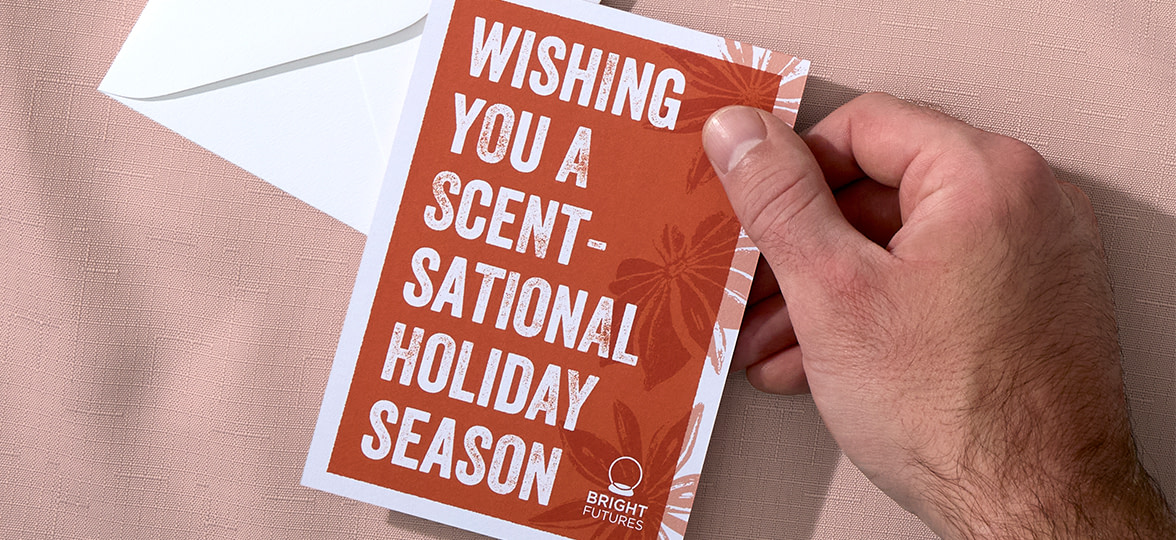 A hand holding a holiday card with a unique festive design.