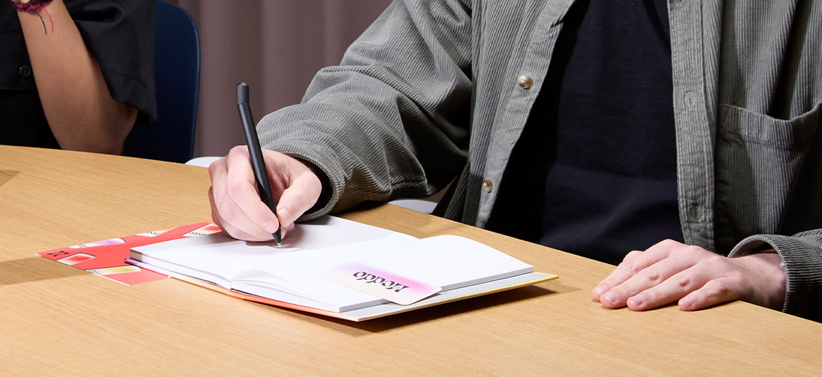 Someone taking notes during a meeting in a notebook