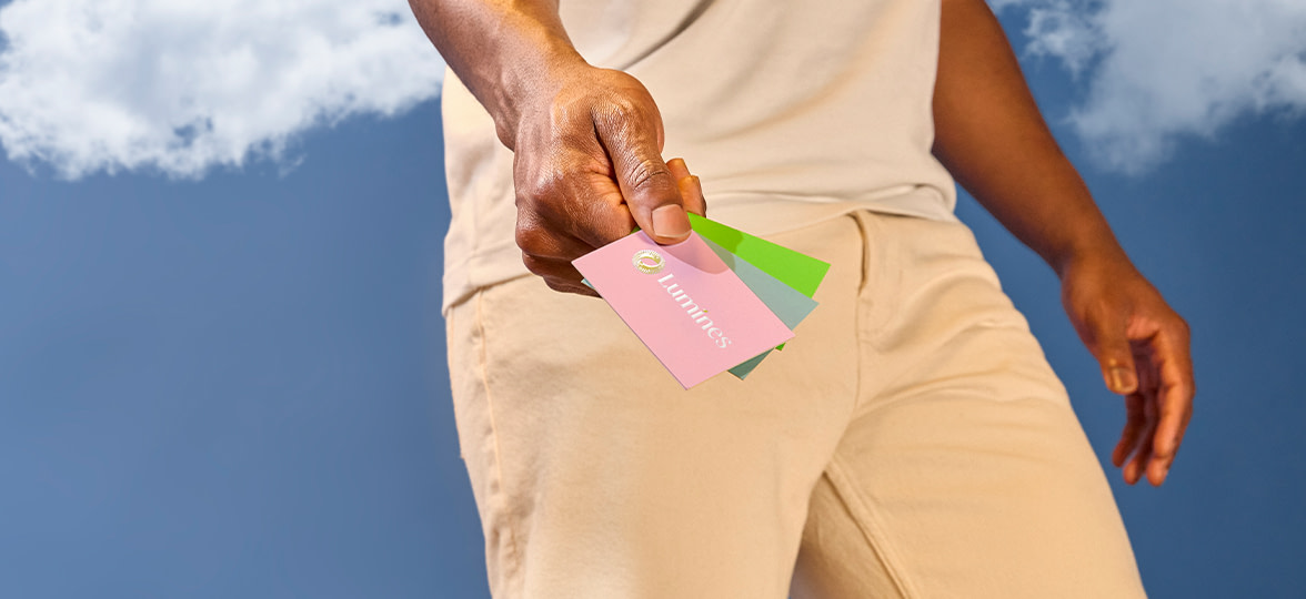 Three MOO business cards in hand