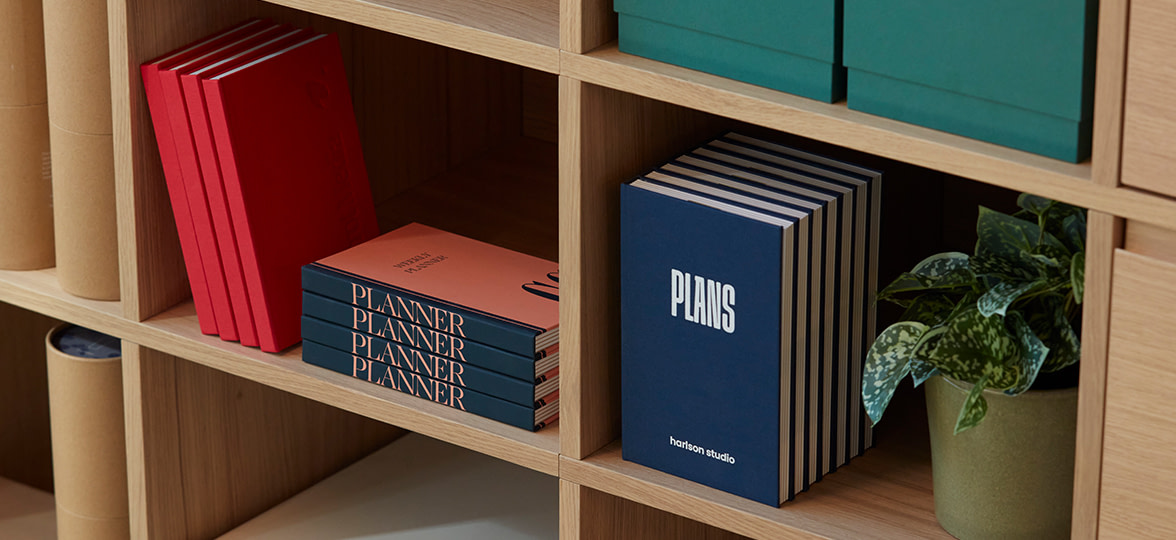 Branded Perpetual Planners displayed on wooden bookshelf.