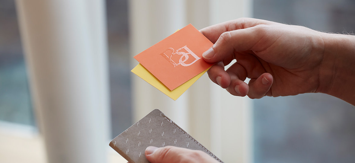 A Raised Spot Gloss business card being held in the light to show the texture