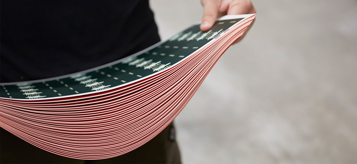 Someone holding a stack of sustainable print paper.