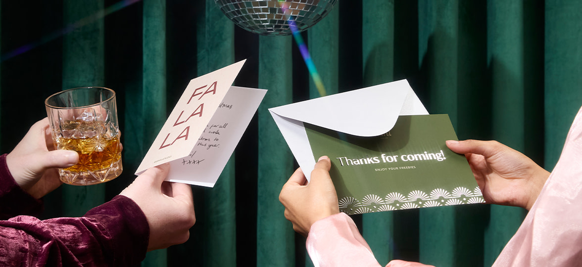 Two people looking at a MOO Greeting Card and Notecard