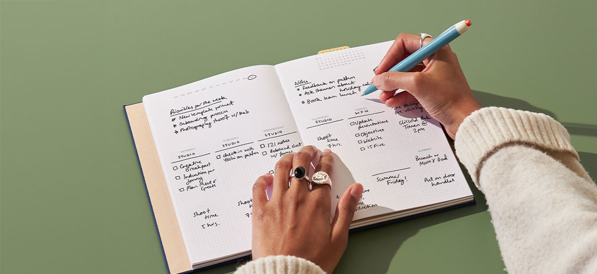 Person writing on Notebook.