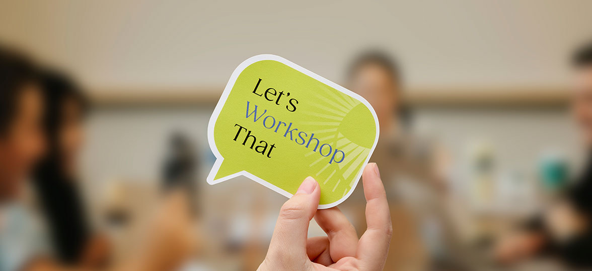 Person holding die cut sticker at a workshop.