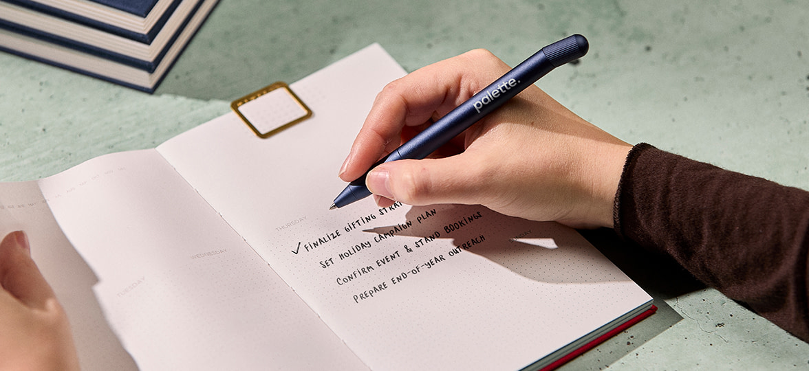 Person writing on Notebook.