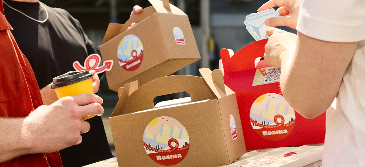 Two people holding branded boxes