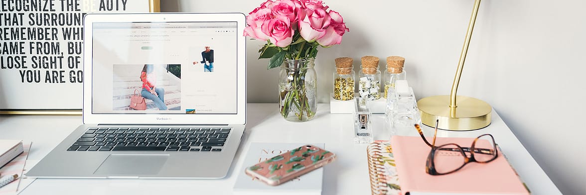 Laptop, roses, phone, notebook and desk decorations to embrace the remote work trend