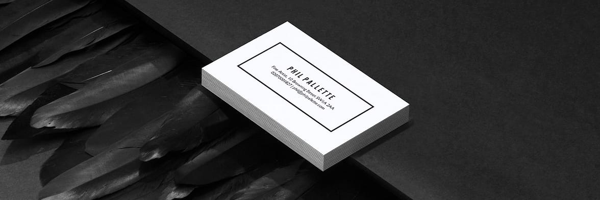 Pile of extra thick white business cards with a minimalist design making use of negative space