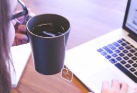 person working and drinking tea