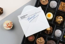 Thank you handwritten note in envelope on a box of chocolates