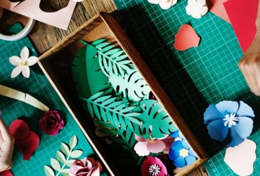 People cutting out paper shapes at a crafts table