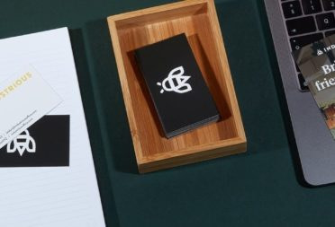 Industrious referral rack card, black business card with a bee logo and other marketing collaterals by Industrious