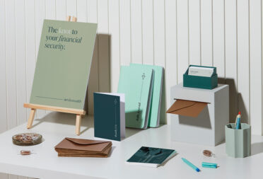 A display table at an event with notebooks, flyers, and marketing materials.