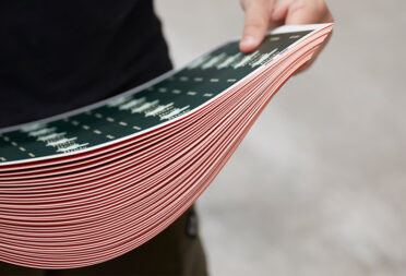 Someone holding a stack of sustainable print paper.