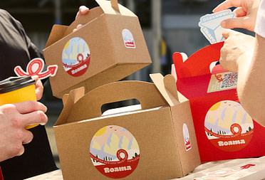 Two people holding branded boxes