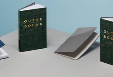 4 custom branded notebooks including a blue notebook with gold foil design, 2 green notebooks with gold foil and one grey softcover notebook