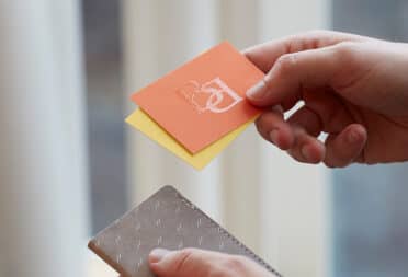 A Raised Spot Gloss business card being held in the light to show the texture
