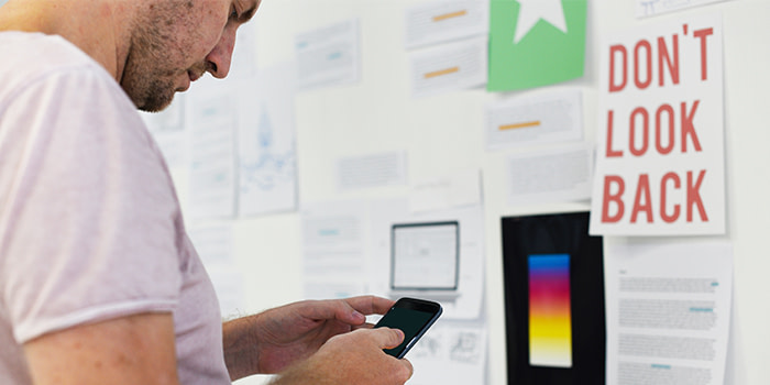 Person on phone in front of wall