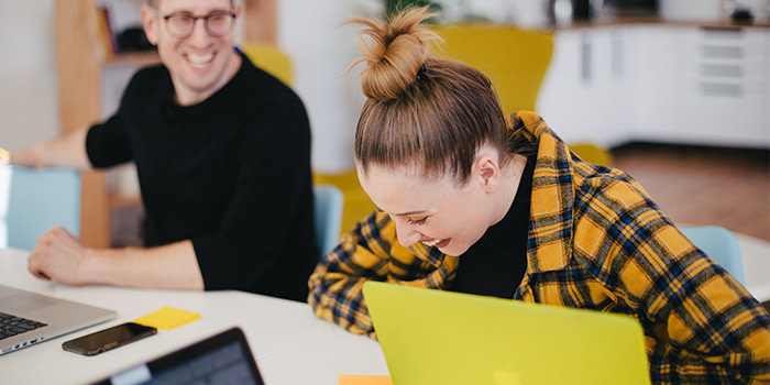two employees laughing together