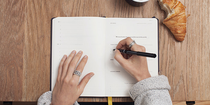 Writing in a notebook planner
