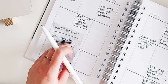 Writing with a pen in a busy daily planner