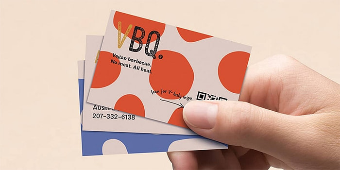 Hand holding 3 QR code business cards