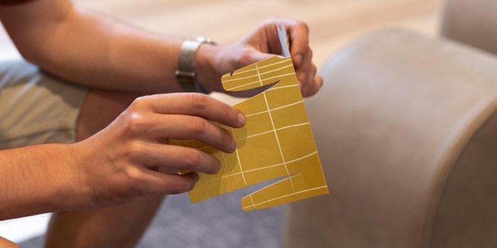 Hands putting together a MOO paper face mask