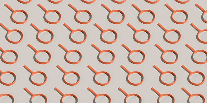 Orange magnifying glasses forming a pattern on a white background
