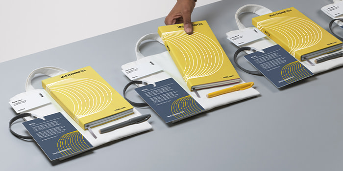 Onboarding packs lined up with notebooks, postcards, and business cards.