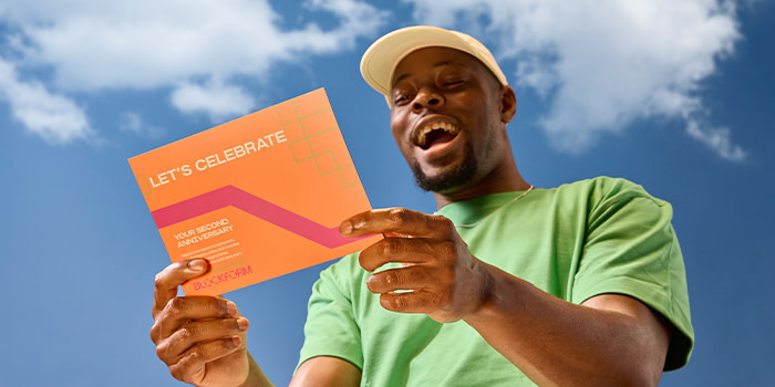 Happy employee holding a promotion Postcard.