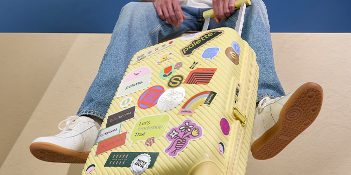 Suitcase with lots of stickers on it.