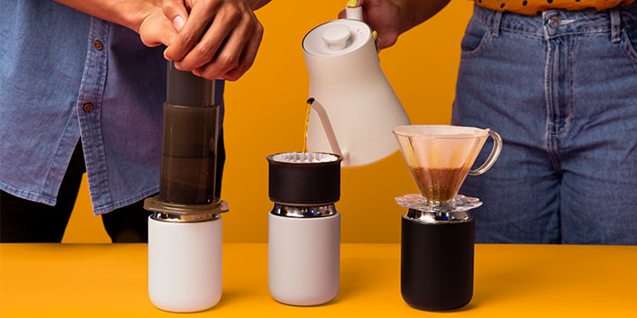 Two people brewing coffee and pouring it.