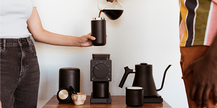 Two people at coffee station.