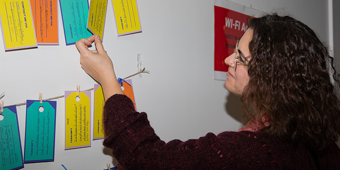 Woman looking at gift-tag wall.