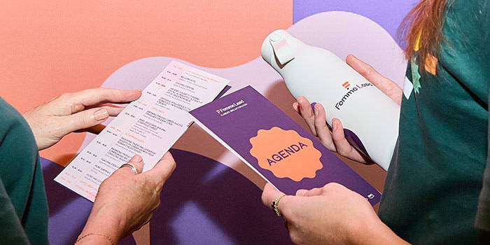 People looking at print and merch at tradeshow.