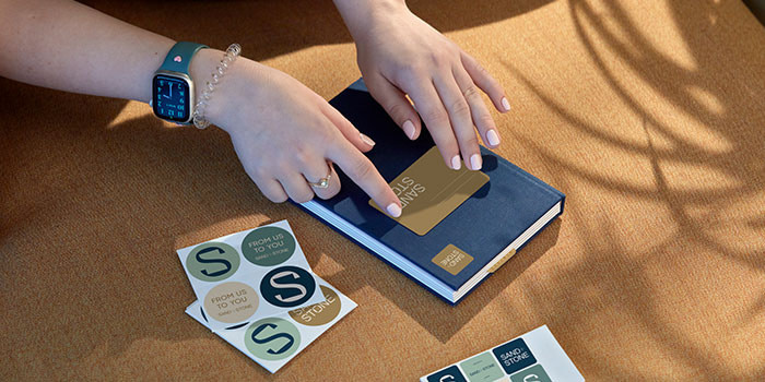 Person sticking name tag to Notebook.