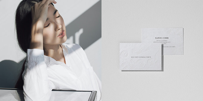 Minimalist standing in shade with a MOO Luxe Business Card.