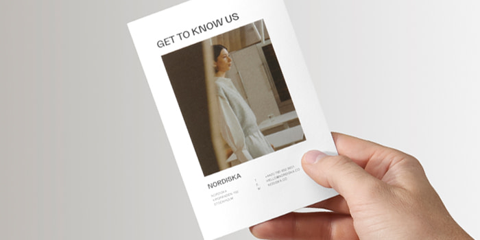 Someone holding a minimalist About Us page