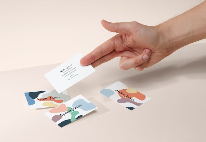 Hand holding colorful busness cards with serif font