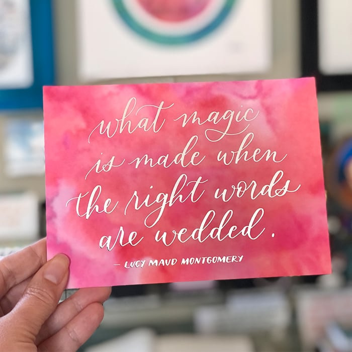 Hand holding a postcard wilver foil lettering design on a pink watercolor background by Bright Spot Papier