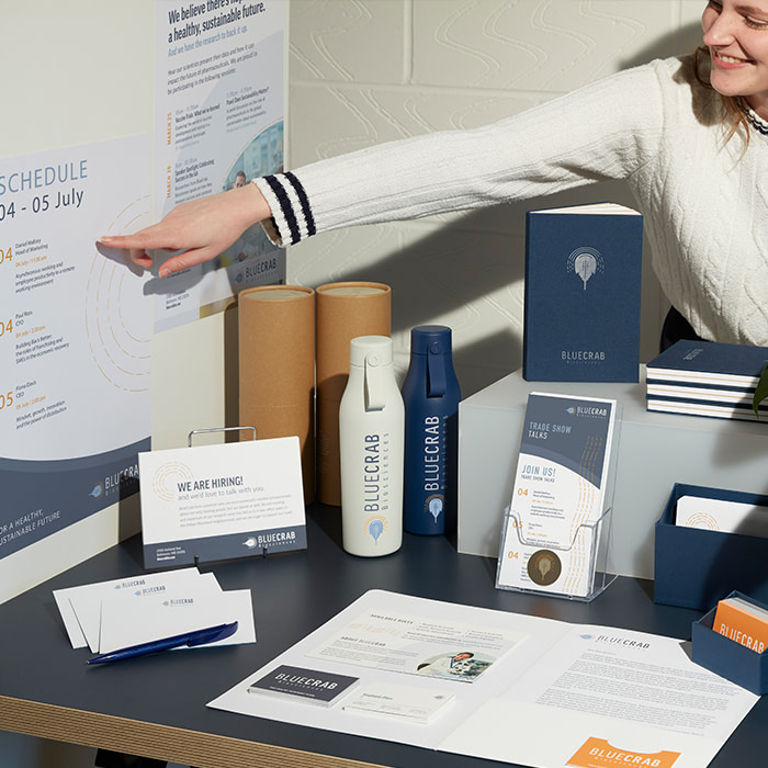 A trade show stand with marketing materials including business cards, postcards, posters and flyers