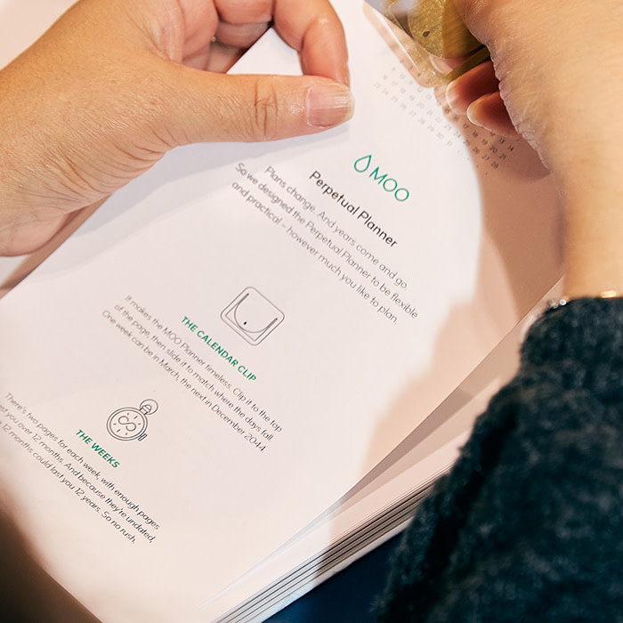 The inside of a MOO planner, showing off our golden calendar clip.