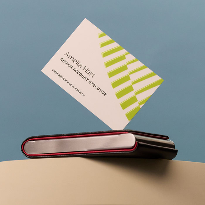 A Business Card displayed at an angle on a silver Business Card holder.