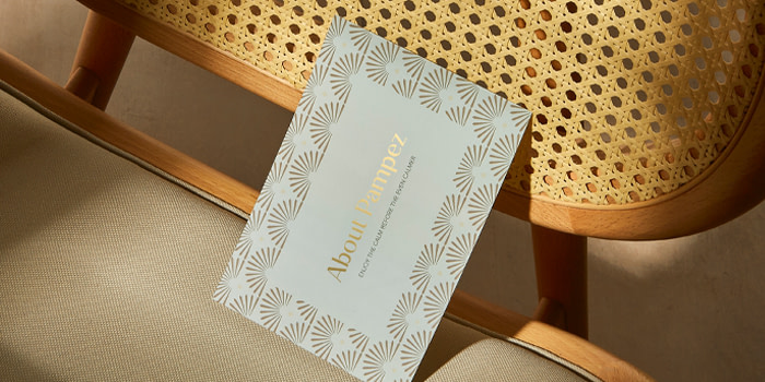 A branded Postcard placed on a brown chair, showcasing a brand's About Us page.